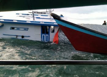 Kondisi saat sebagian badan kapal Km Sinar Mulya 06 tenggelam dan terlihat perahu nelayan membantu proses evakuasi.