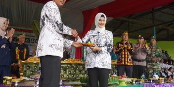 Bupati Nunukan Laura Hafid memberikan potongan tumpeng secara simbolis kepada Ketua PGRI Kabupaten Nunukan.