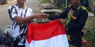 Ketua FYKAB Kabupaten Tana Tidung Dt. Khairul Sadik membagikan bendera merah putih kepada warga Tana Tidung.